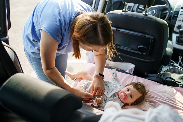 mama care schimba scutecul bebelusului ei in masina