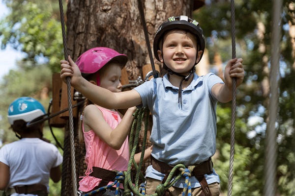 copii echipandu-se pentru distractie intr-un parc de aventuri