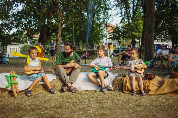 grup de copii participand la un atelier de cantat la ukulele