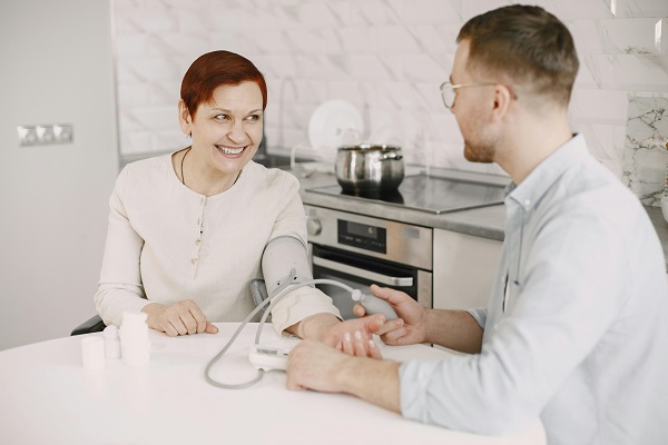 medic care masoara nivelul tensiunii arteriale unei femei vesele