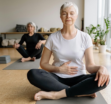 femeie matura in timp ce incearca sa relaxeze in timpul unei sesiuni de yoga