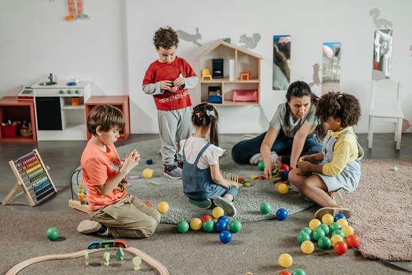 copii jucandu-se sub supravegherea unui cadru didactic la gradinita