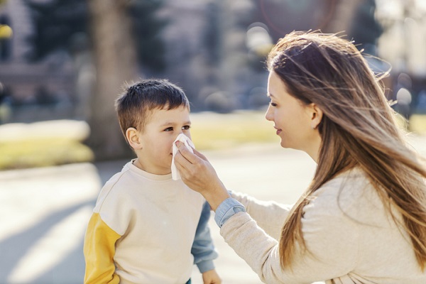 mama care sterge nasul baietelului ei la plimbare