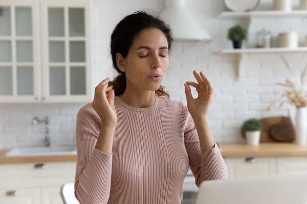 femeie care încearcă să se calmeze cu un exercițiu de respiratie