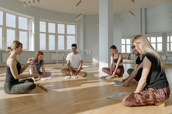 grup de tineri ce se pregatesc de o sedinta de yoga