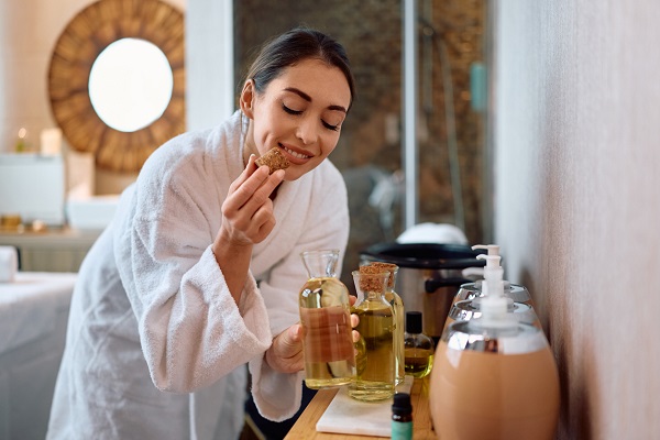 femeie in halat de baie alegand uleiuri pentru o sedinta de spa