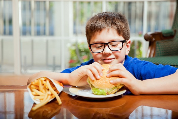 baiat cu ochelari mananca burger