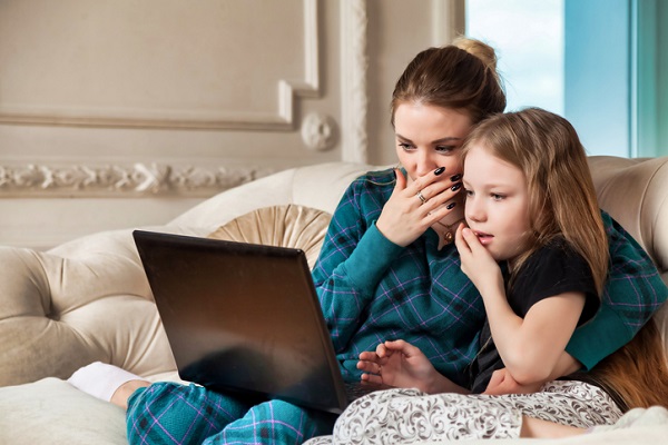 mama si fiica surprinse de ceea ce vad pe laptop