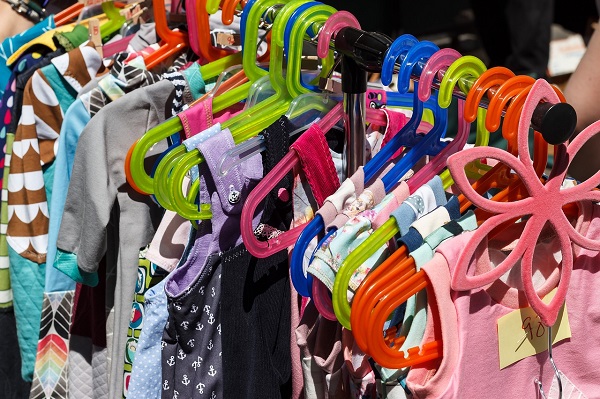 mai multe haine de copii puse pe umerase colorate