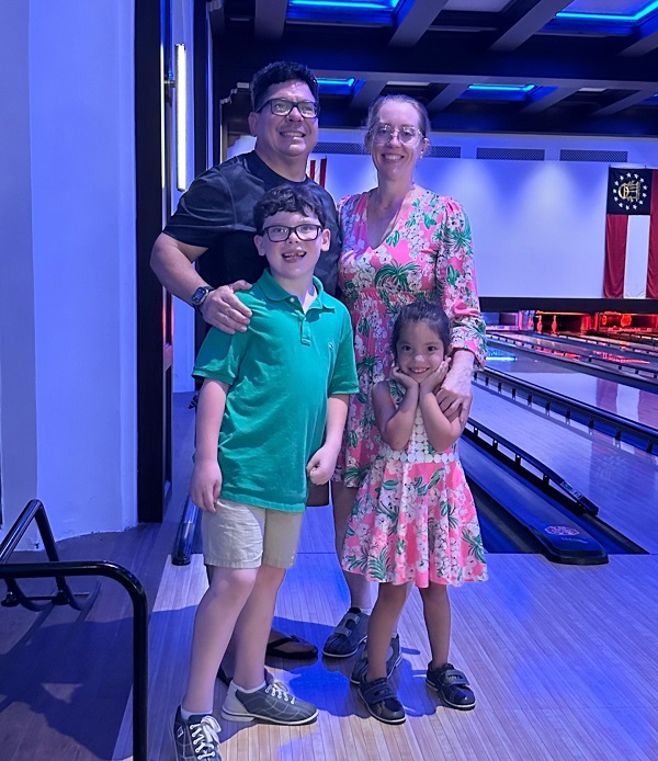 familie formata din mama tata fiu si fiica in lumina albastra la bowling