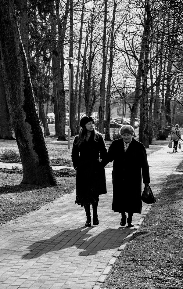 doua femei de varste diferite se plimba in parc imbracate gros