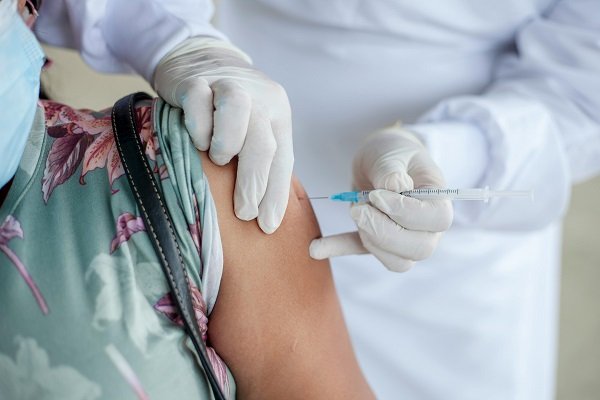 medic vaccineaza o femeie in umar