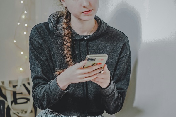 fata adolescenta cu telefon in mana