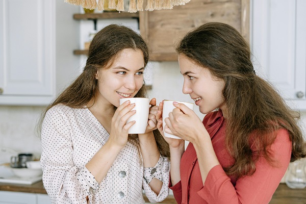 doua surori gemene beau cafea in bucatarie