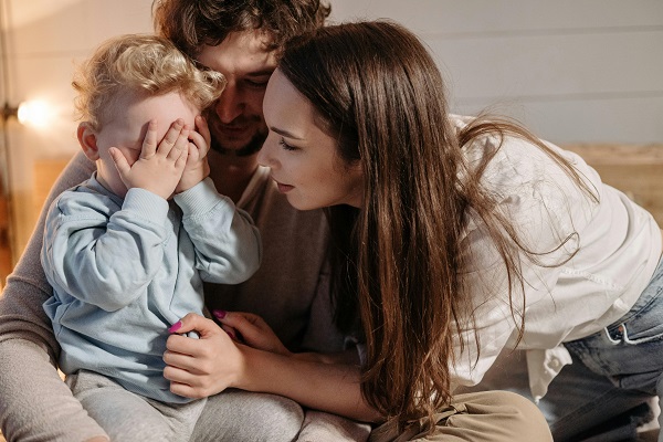 mama si tata consoleaza copilul care plange