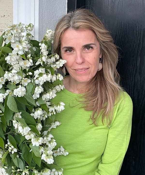 cristela georgescu imbracata in verde tine un buchet de flori albe in mana