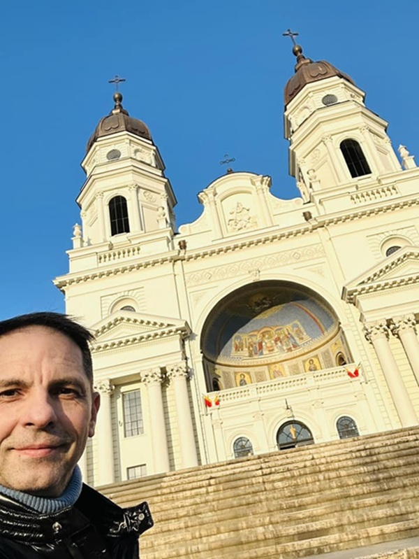 dan negru isi face un selfie in fata unei biserici